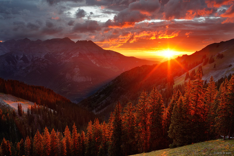 A brilliant sunset beams through the Uncompahgre River valley. &nbsp;The town of Ridgway is located below the sunset; Ouray would...